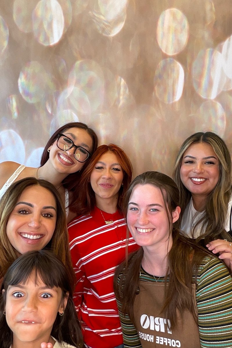 Guests posing at a coffee house grand opening photo booth